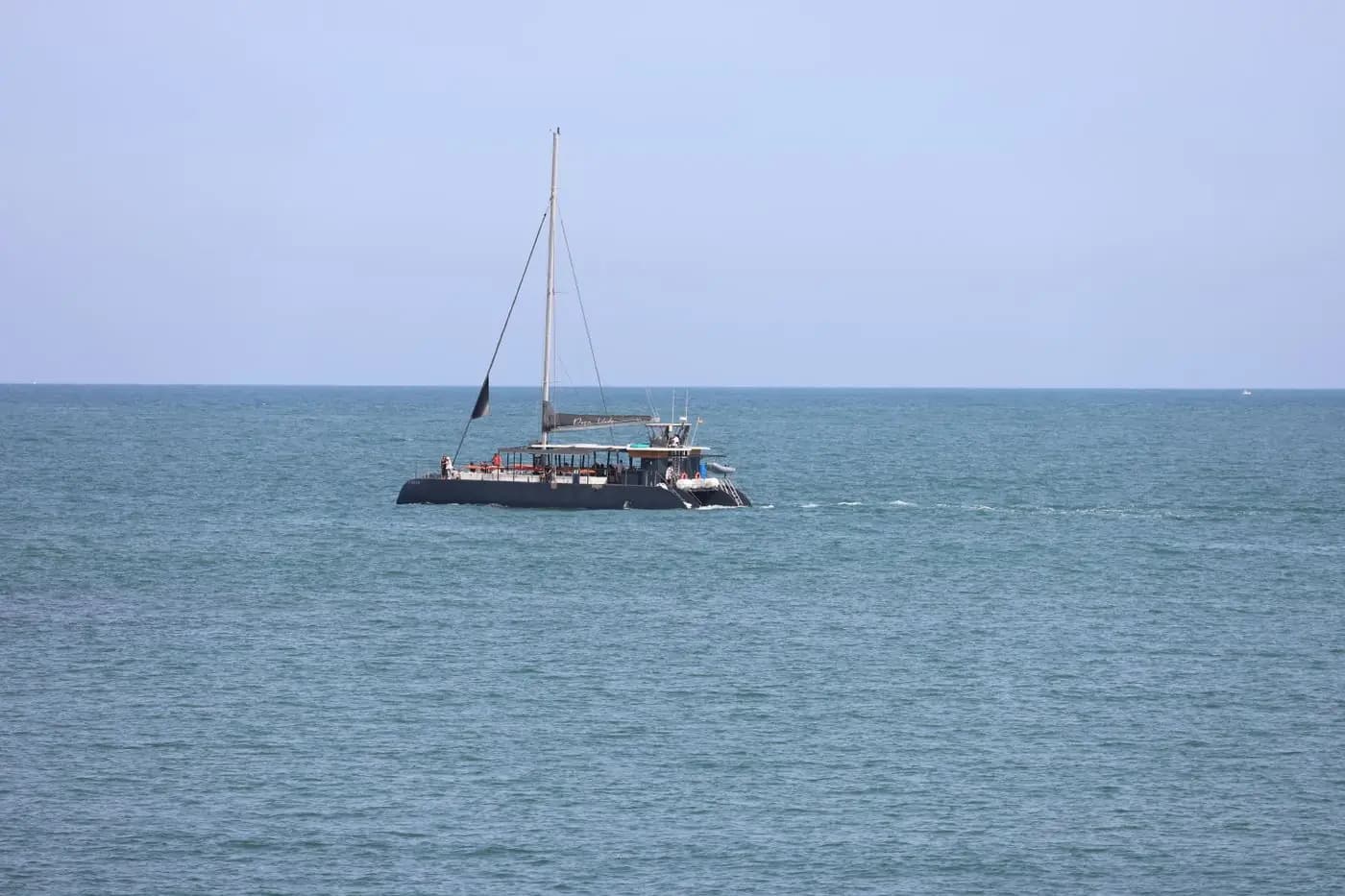 Sailing catamaran on calm sea under a clear sky