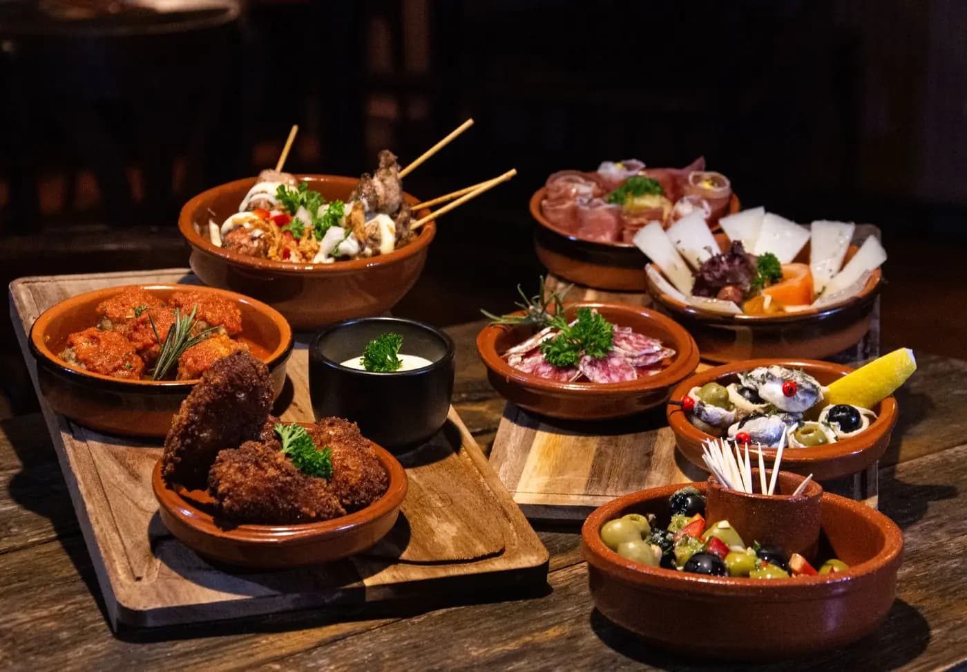 Assortment of Spanish tapas in small clay dishes on a table