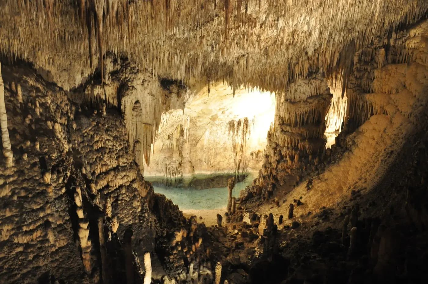 Cave with stalactites and a turquoise underground lake