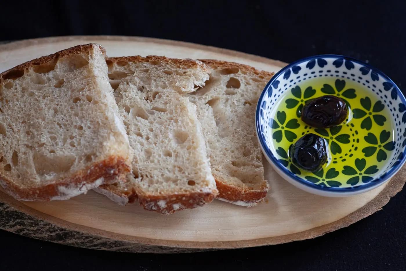 Rustic bread with a bowl of extra virgin olive oil and olives