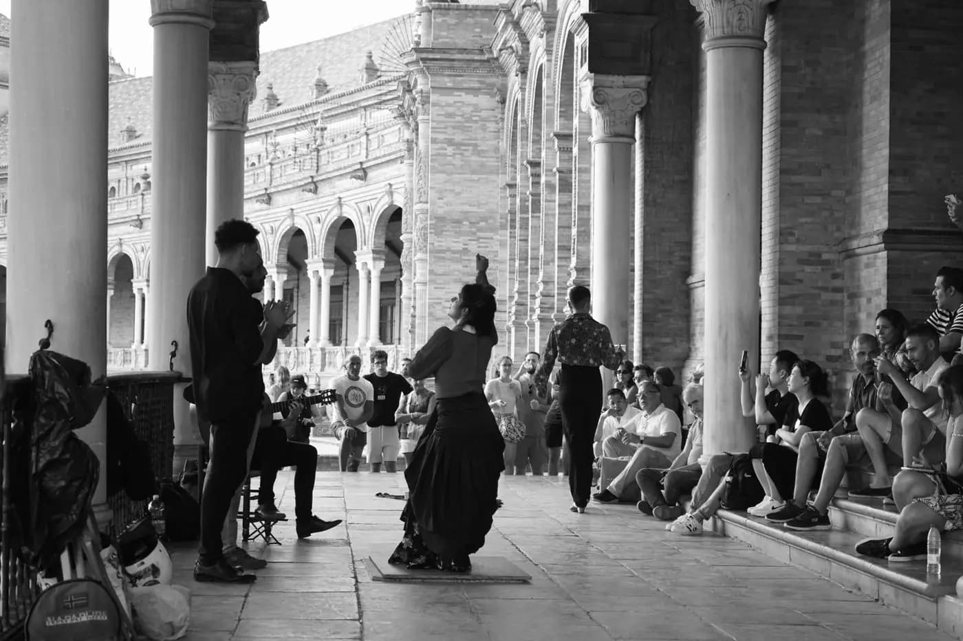 Flamenco dancer and musicians under a gallery in Seville, in black and white