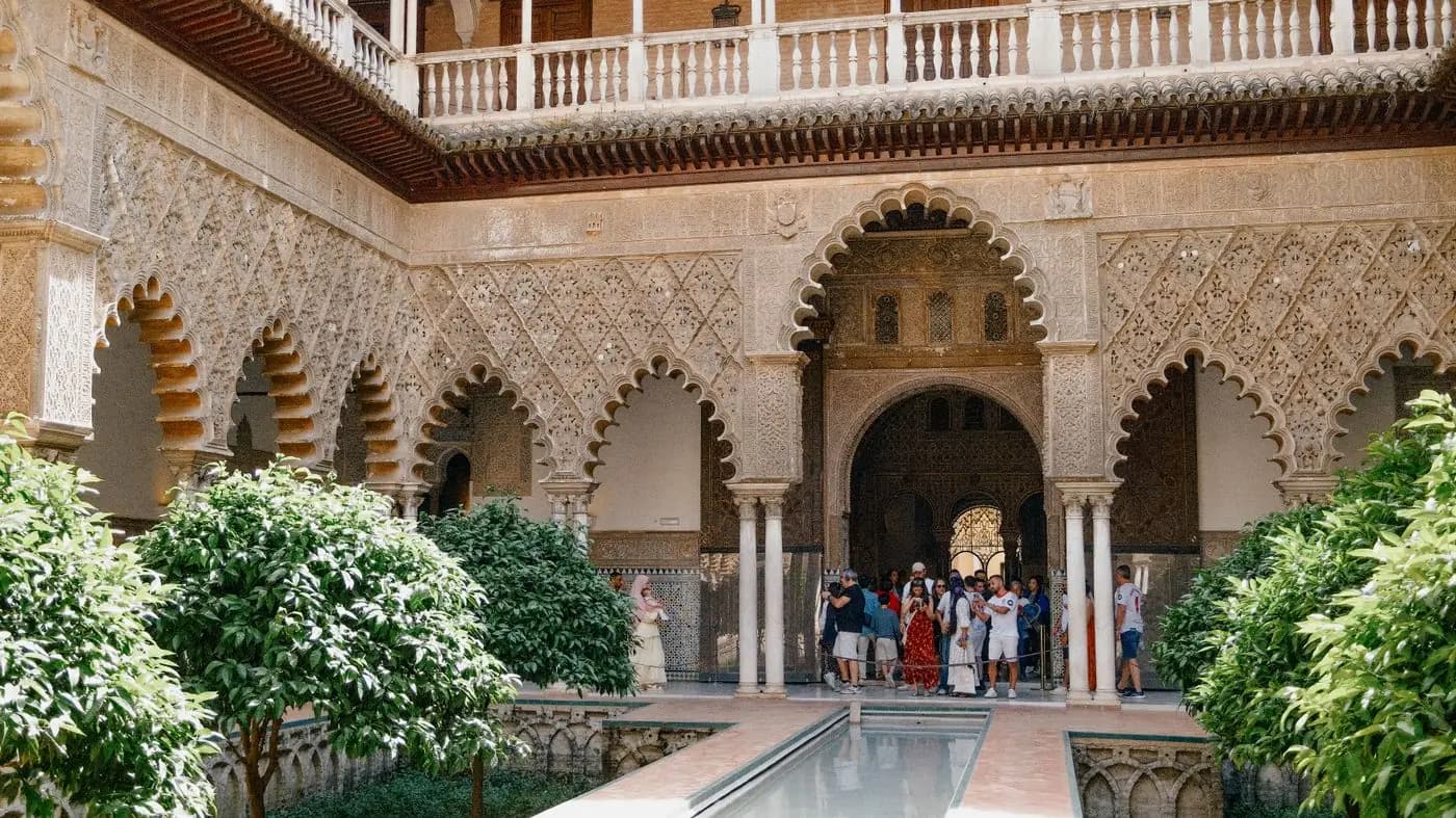Mudejar courtyard of the Seville Alcázar with carved arches and pool