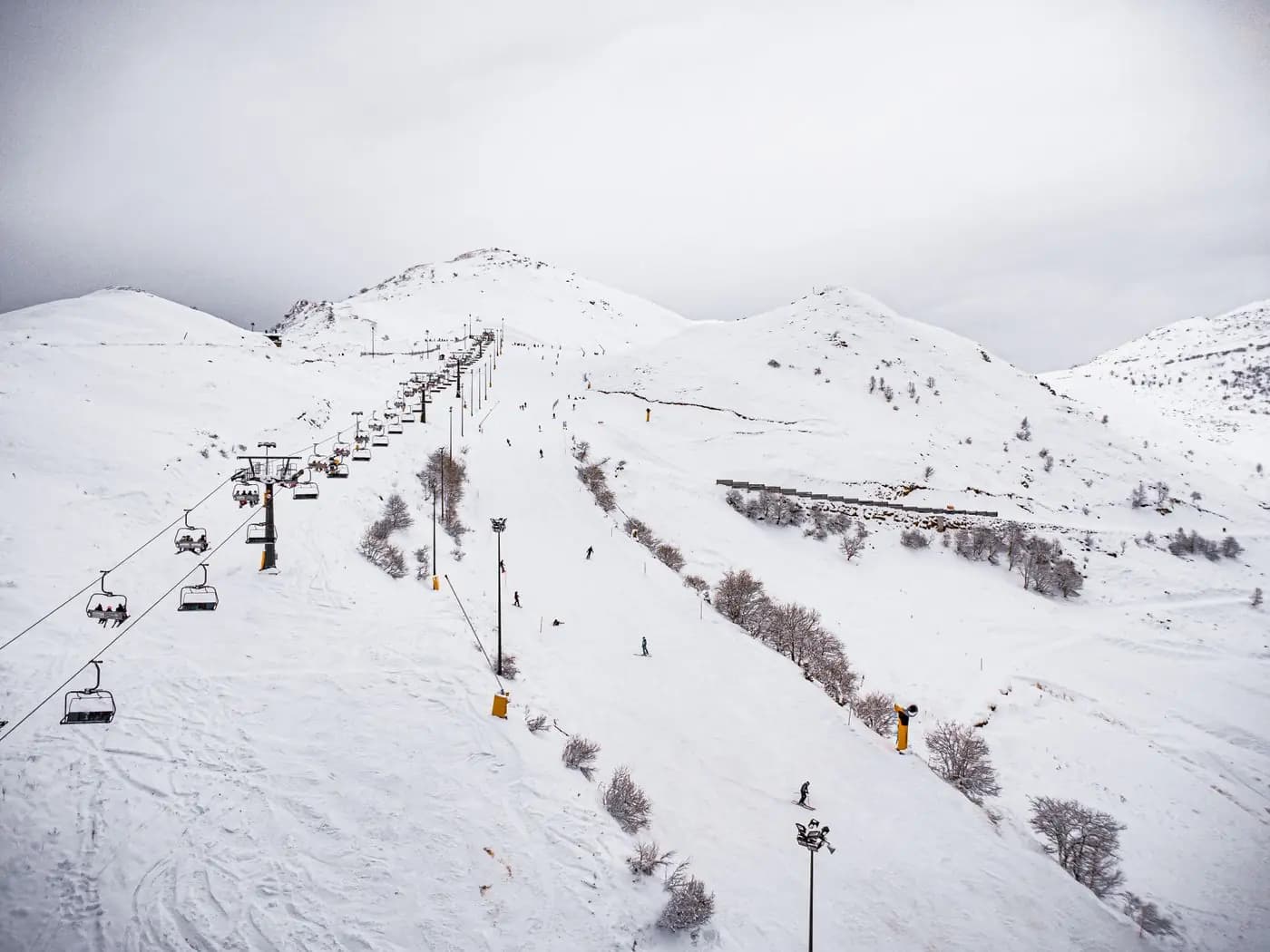 Snowy ski slope with a chairlift and skiers