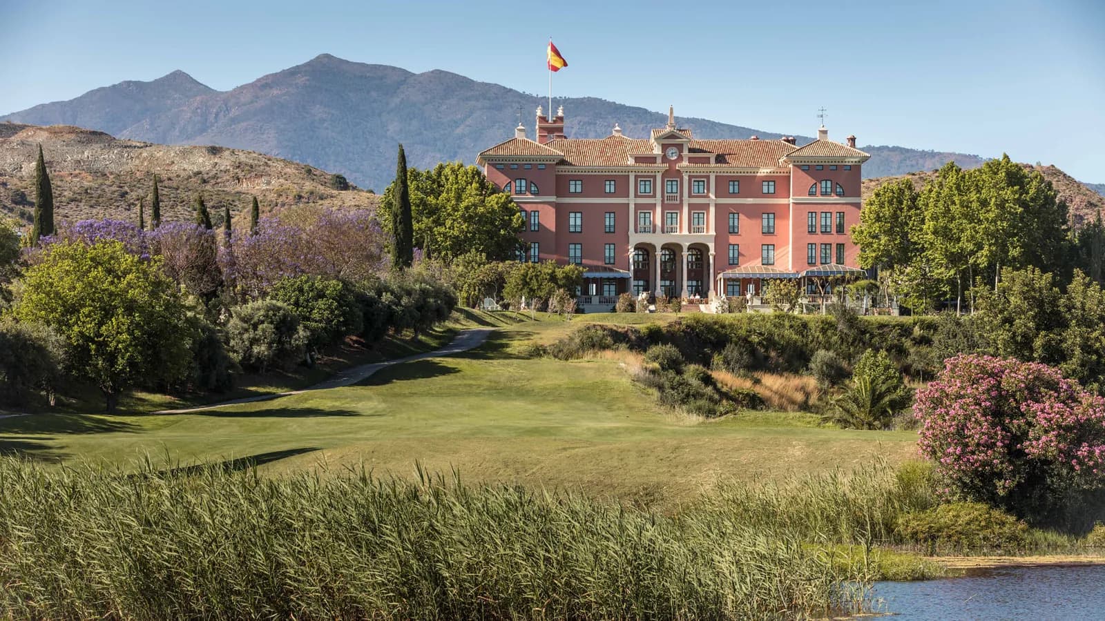 Pink façade of Anantara Villa Padierna Palace overlooking the golf course in Benahavís