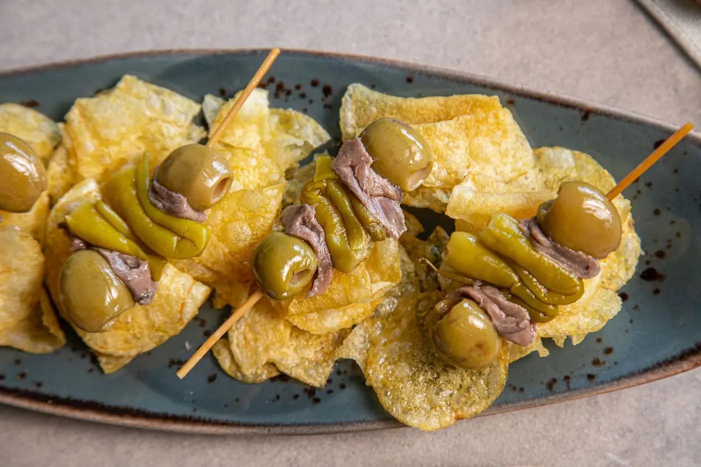 Gilda pintxos with olives, anchovies and peppers on potato chips