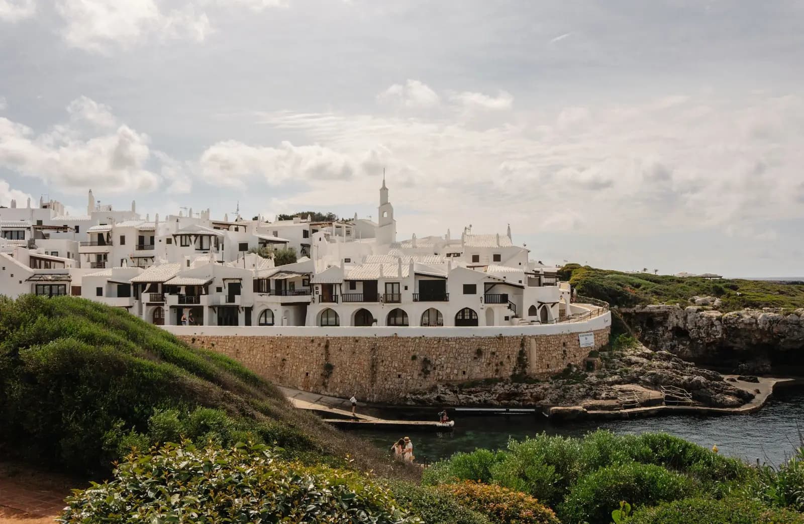 White buildings on a clifftop coastline in Ciutadella