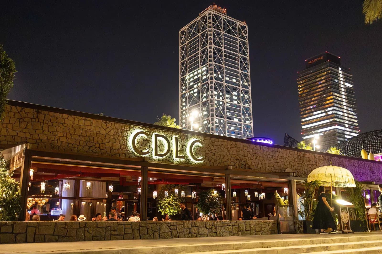 Carpe Diem Lounge Club facade lit up at night with its CDLC sign in Barcelona