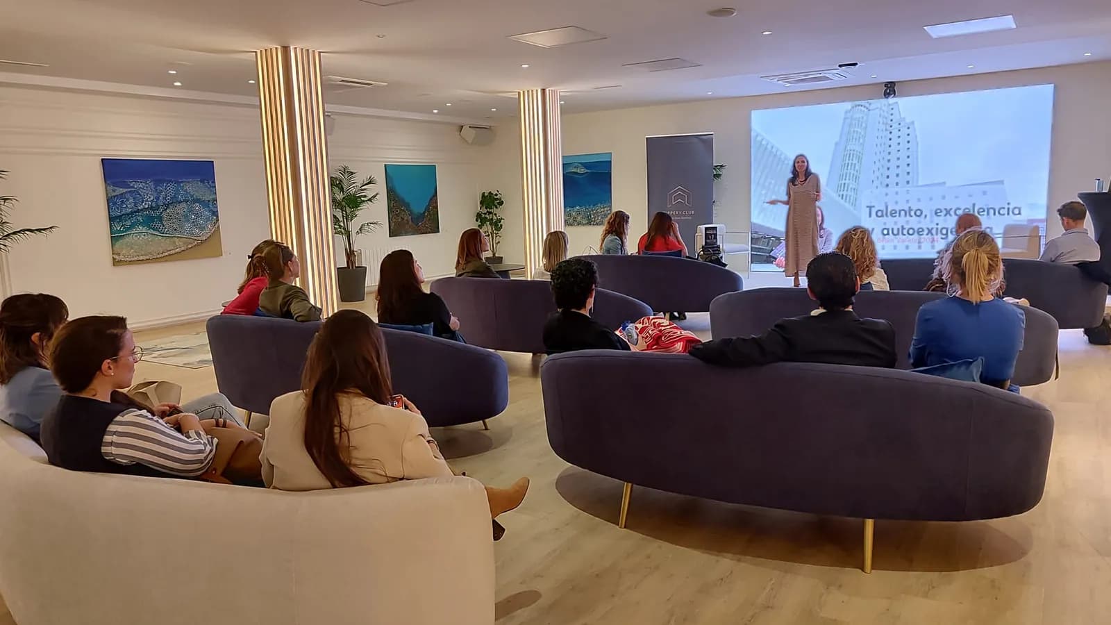 Uppery Club Málaga lounge with purple sofas and projection screen