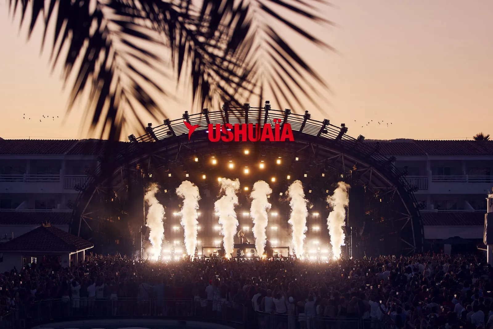 Ushuaïa sign above a stage with flame columns at night in Ibiza