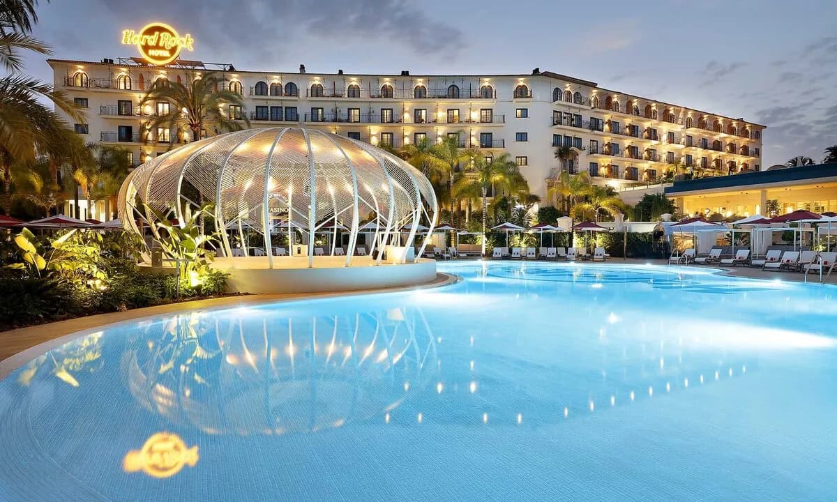 Facade and night-time pool of Hard Rock Hotel Marbella, Puerto Banús