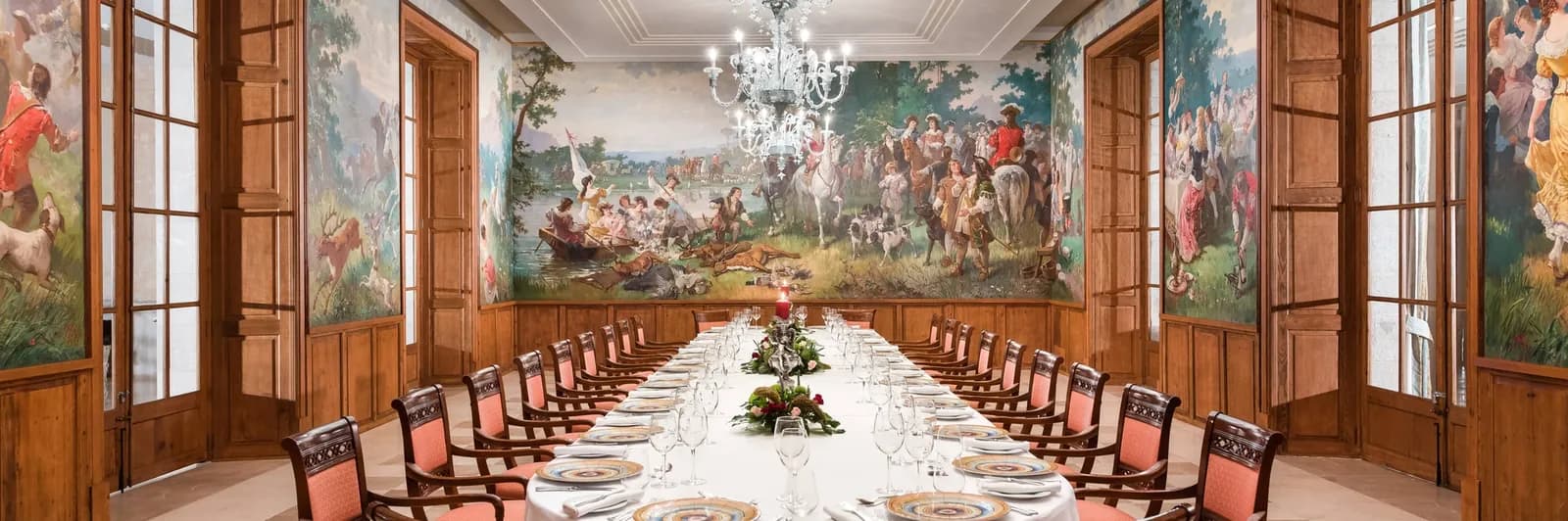 Banqueting hall with frescoes and a long laid table