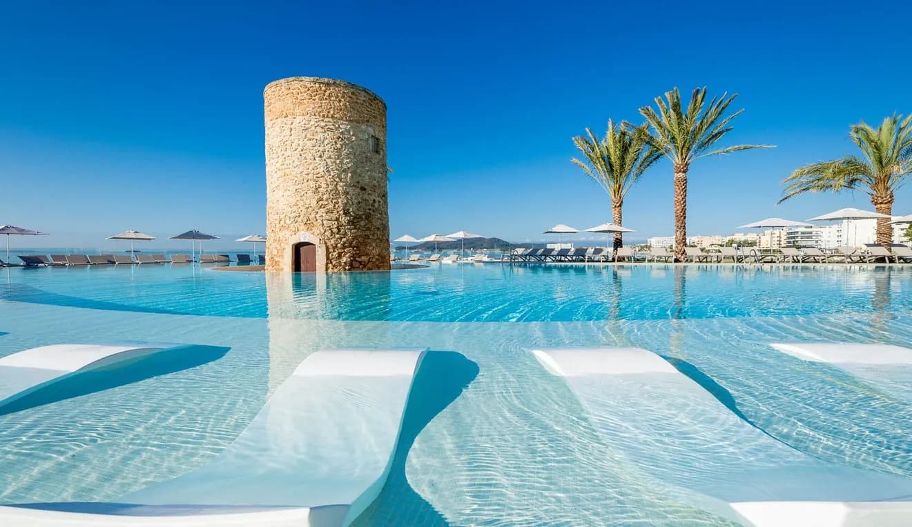 Infinity pool of Hotel Torre del Mar with its historic tower, facing Playa d'en Bossa, Ibiza