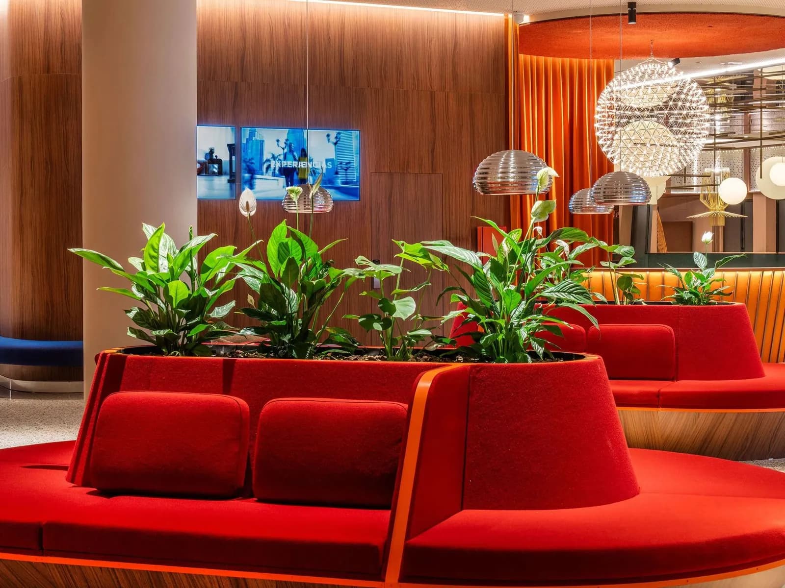 Lounge at the Novotel Madrid Campo de las Naciones, with red sofas and plants