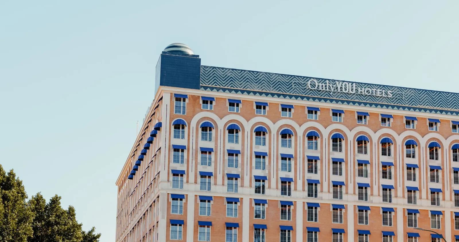 Facade of Only YOU Hotel Sevilla in brick, with the hotel sign