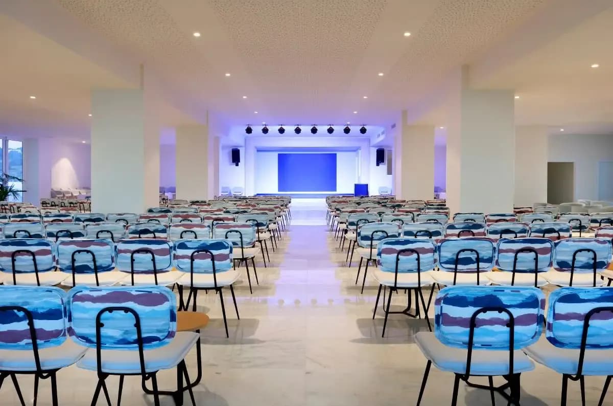 Conference hall with blue chairs facing the stage