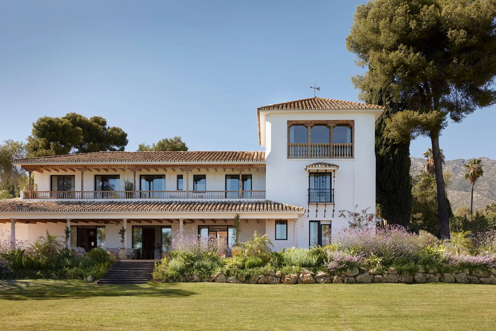 White tiled-roof villa surrounded by lawn at Puente Romano Beach Resort in Marbella