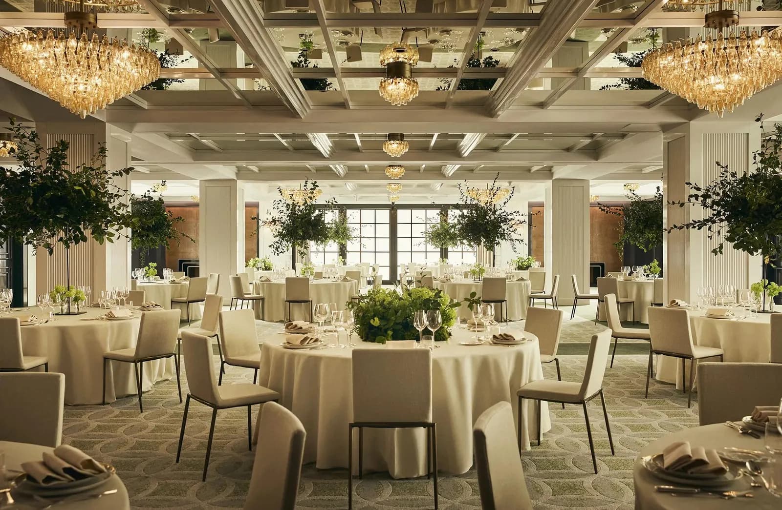 Reception room with round tables under large chandeliers