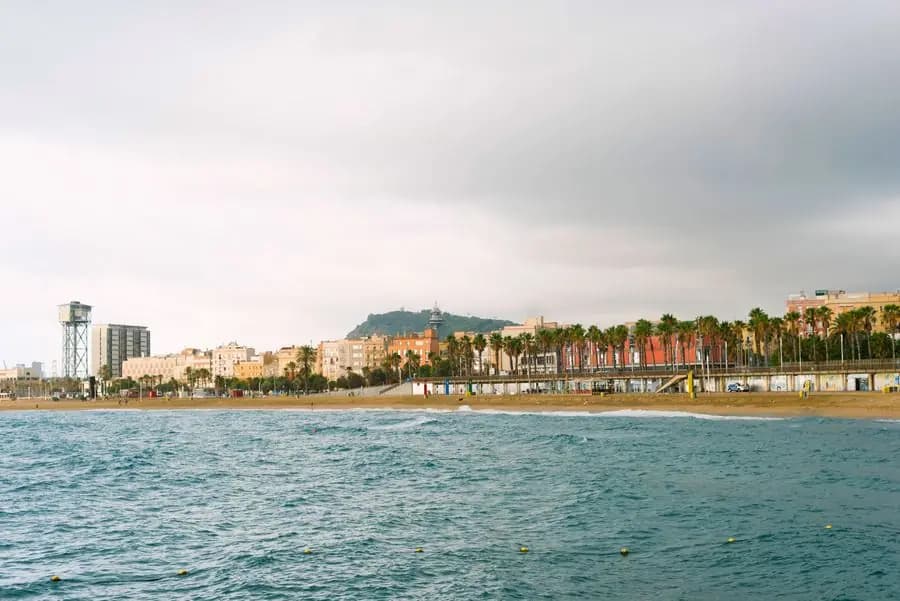 Barceloneta beach and seafront under a cloudy sky