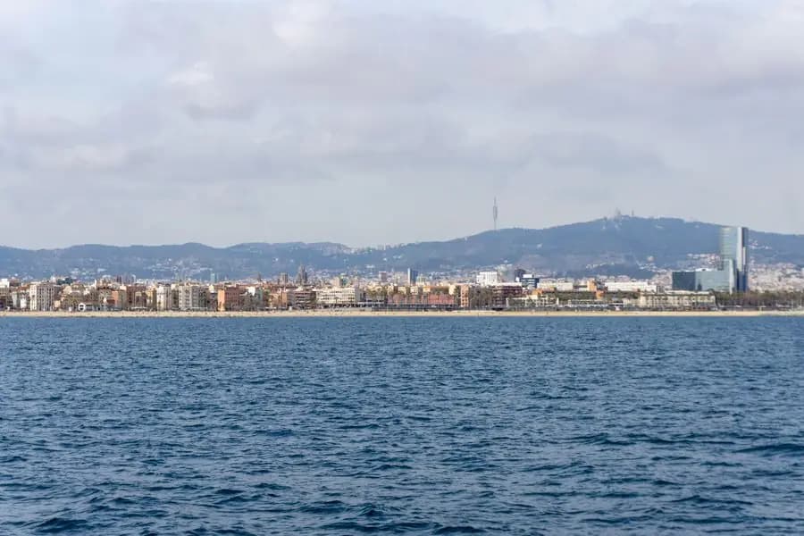 Barcelona coastline with city skyline under a cloudy sky