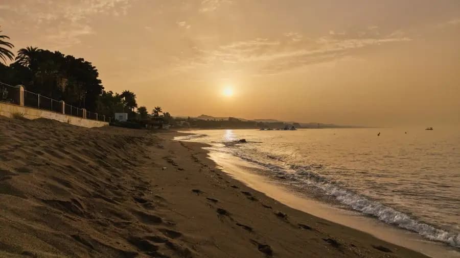 Sunset over the sandy Marbella beach, with gentle waves