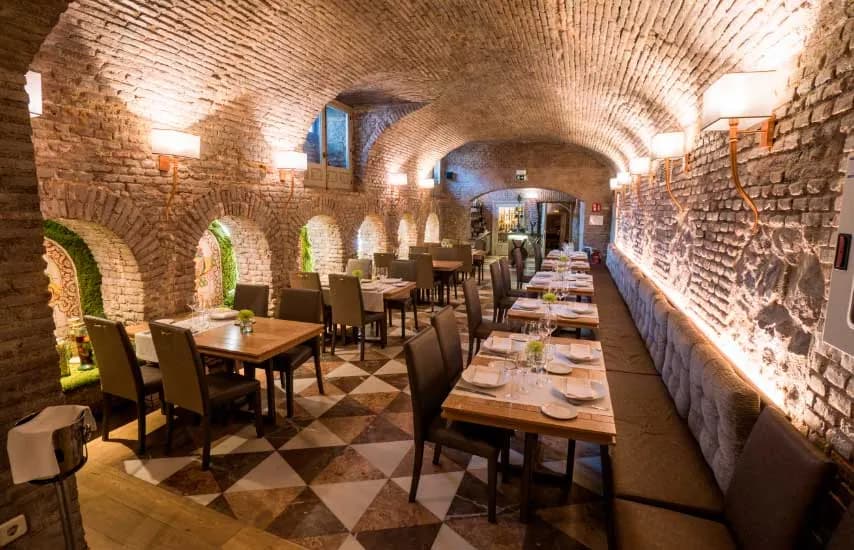 Vaulted brick dining room of Café de Oriente in Madrid with set tables
