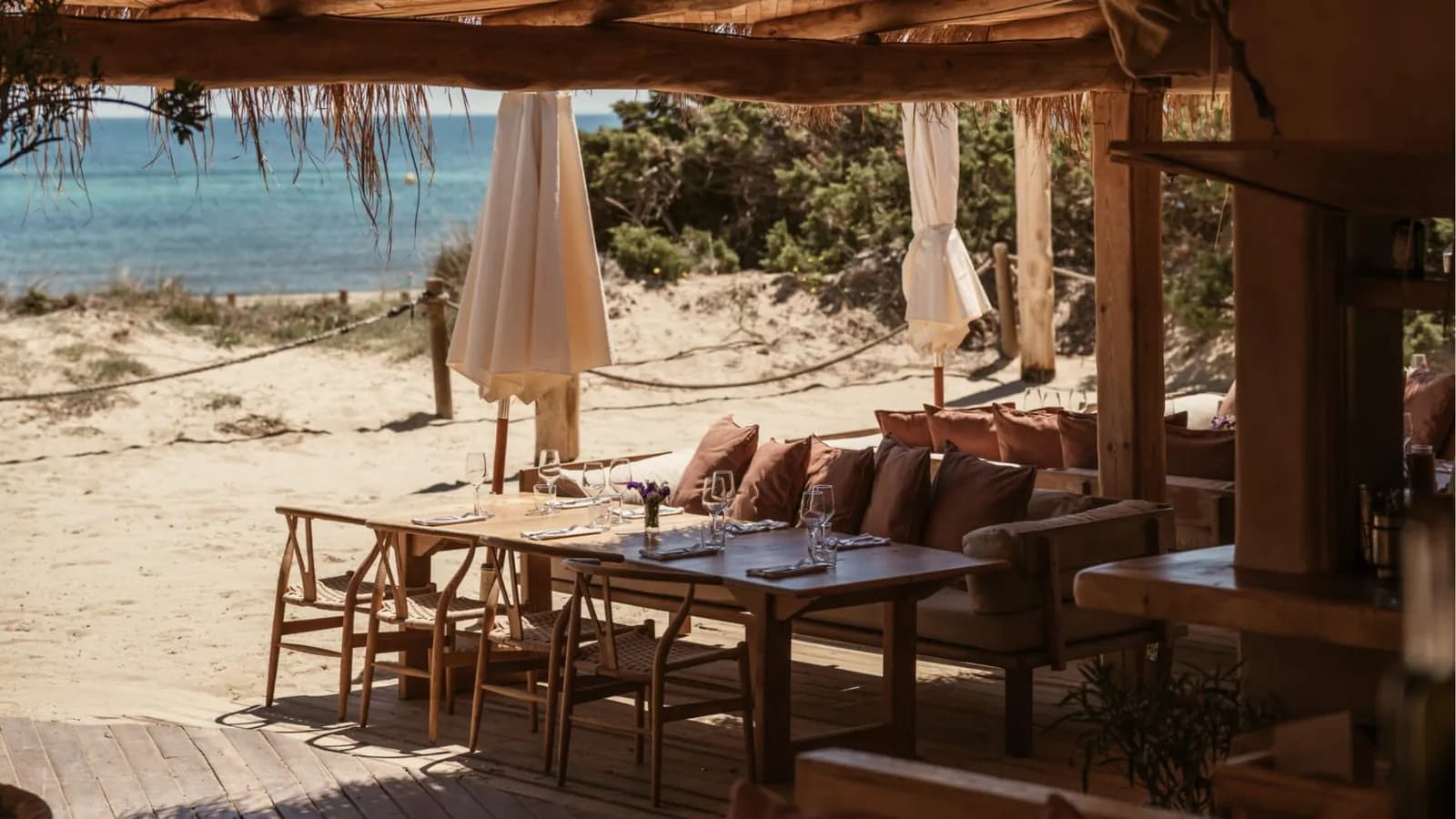 El Chiringuito beach terrace in Ibiza with wooden tables facing the sand