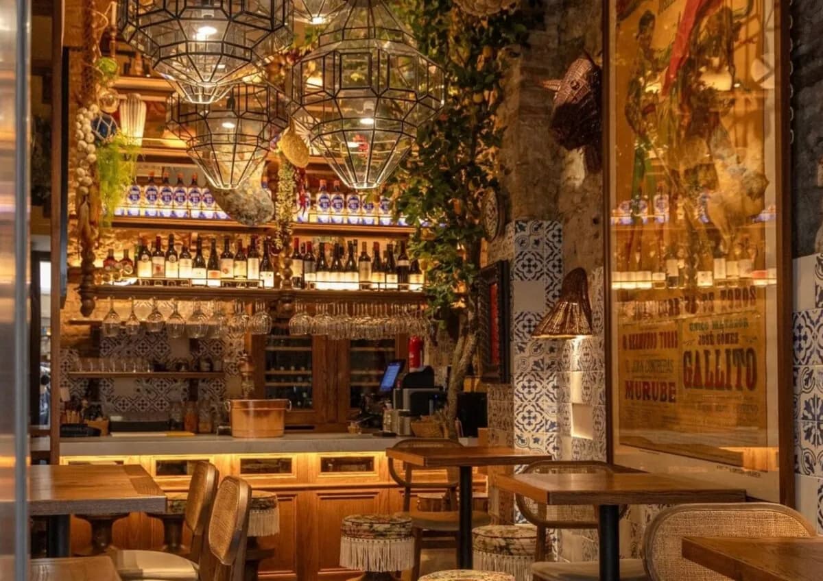 Lively interior of the El Pimpi bar, with a chandelier and plants