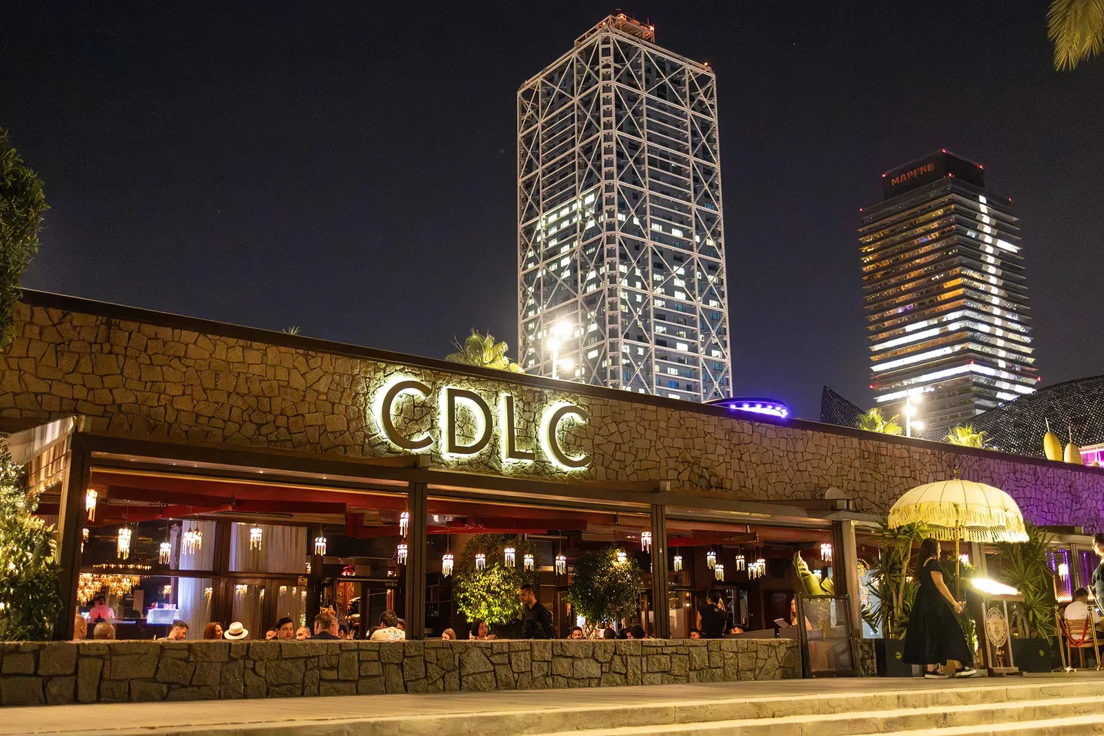 Carpe Diem Lounge Club facade lit up at night with its CDLC sign in Barcelona