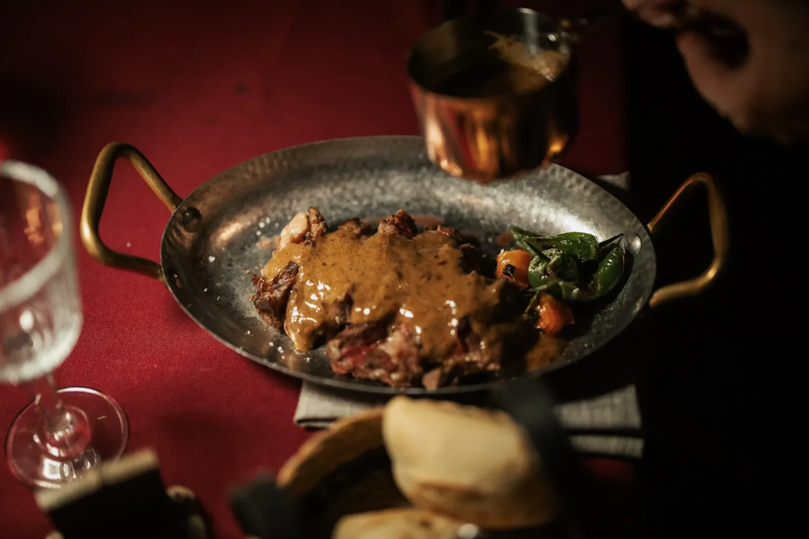 Meat in sauce served in a copper pan at LØV Marbella restaurant