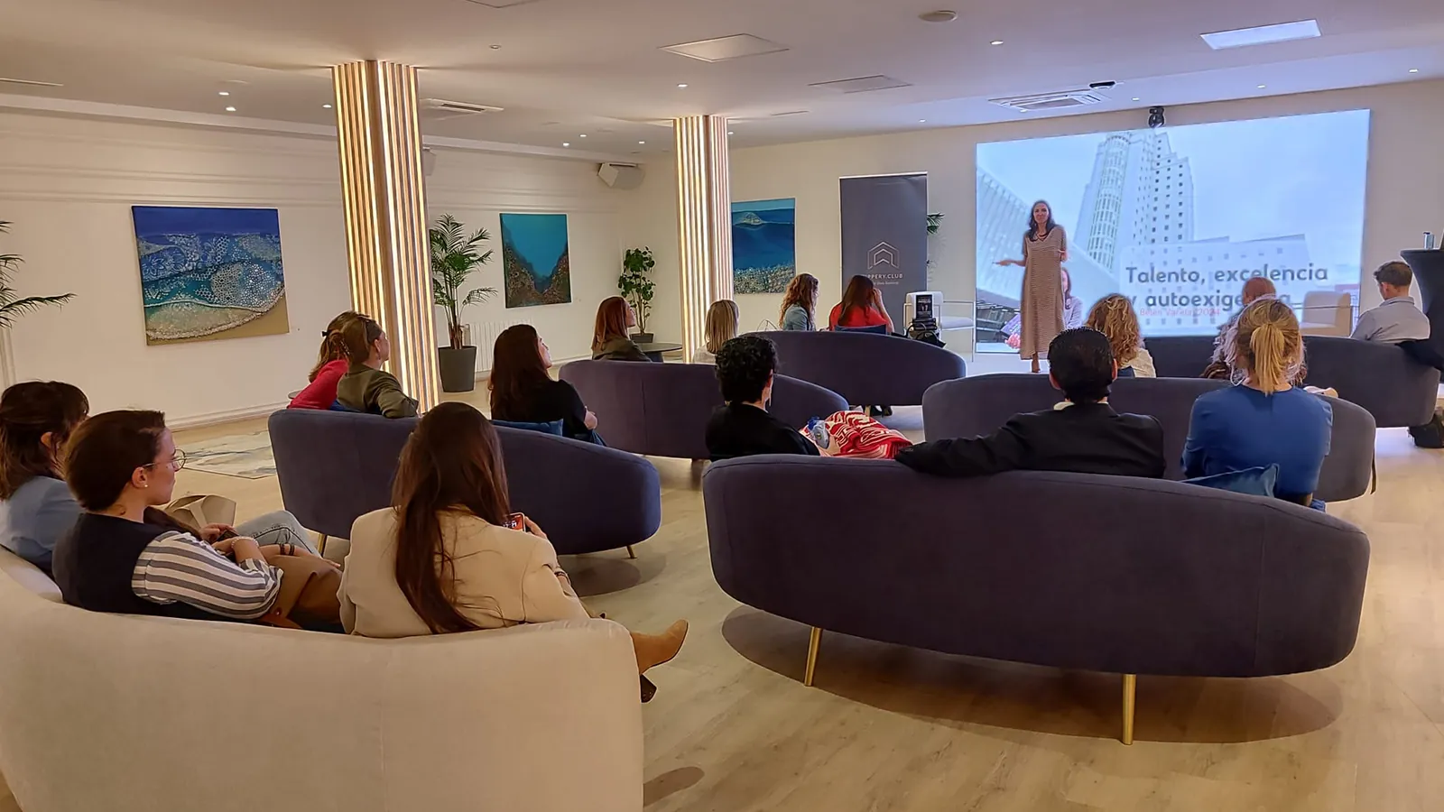 Uppery Club Málaga lounge with purple sofas and projection screen