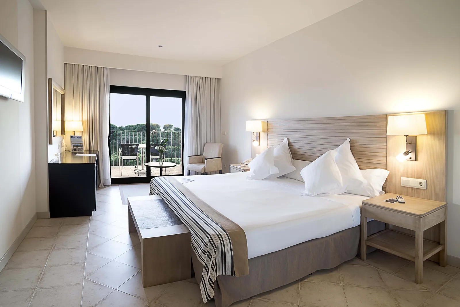Bright junior suite with white bed and balcony at Barceló Punta Umbría Beach Resort