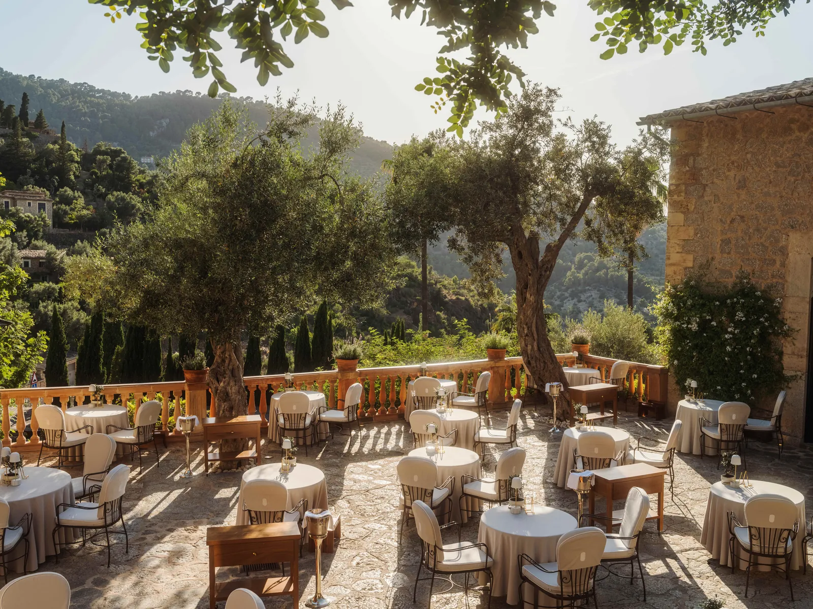 Terrace of El Olivo restaurant at La Residencia under olive trees in Deià