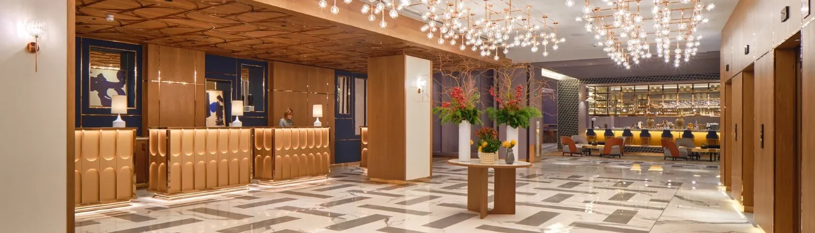 Wood-paneled reception area with chandeliers at InterContinental Barcelona in Barcelona