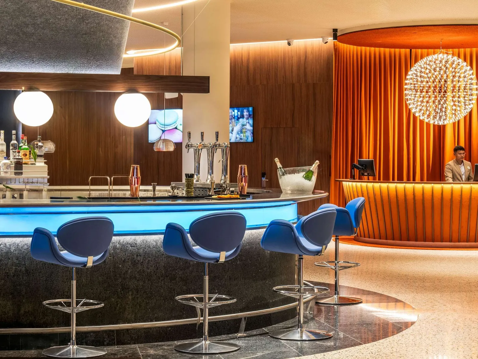 Modern bar with blue stools at Novotel Madrid Campo de las Naciones