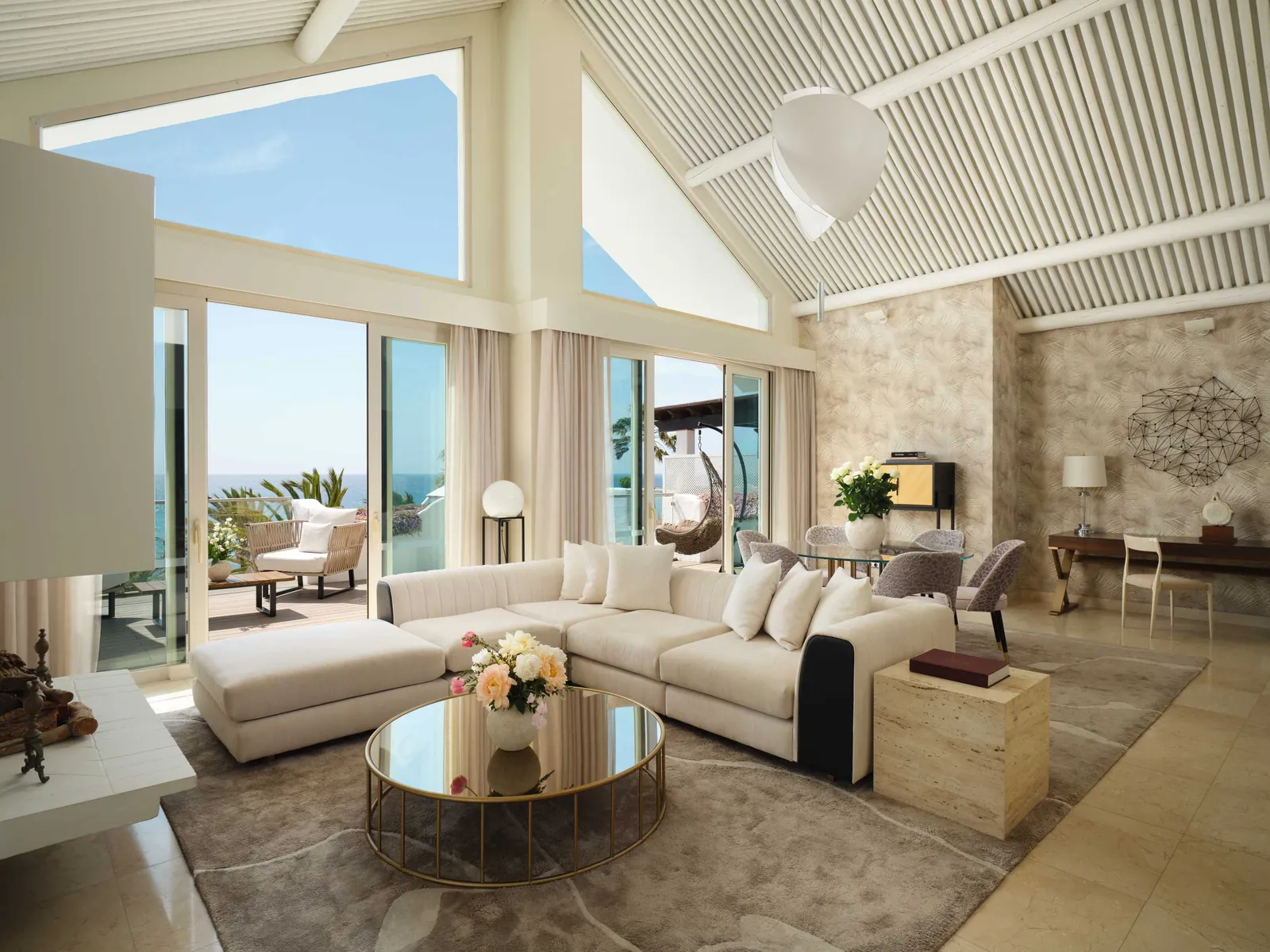 Bright suite living room with white sofa and large windows at Puente Romano