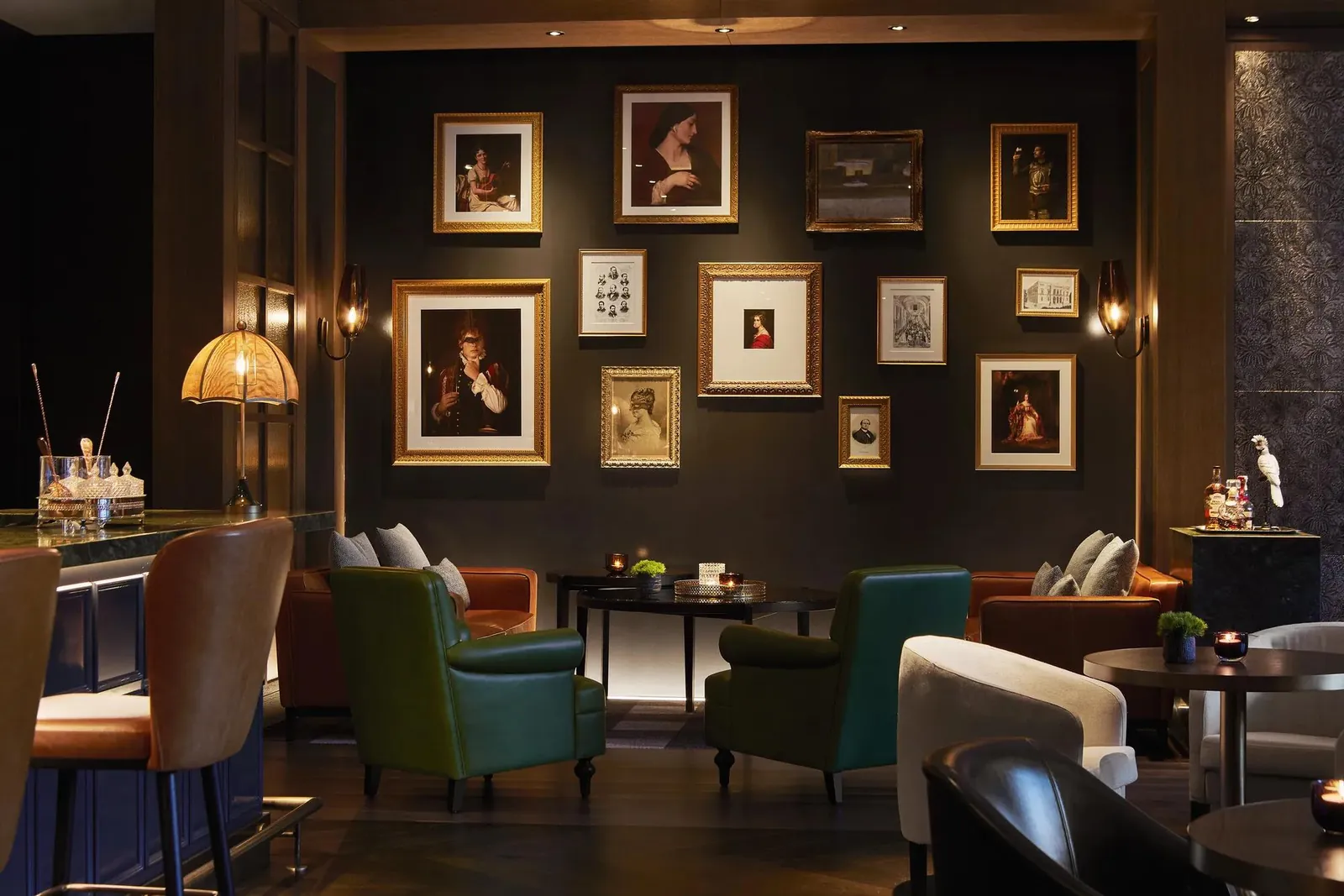 Tarde O bar with art-covered wall and colorful armchairs at Rosewood Villa Magna