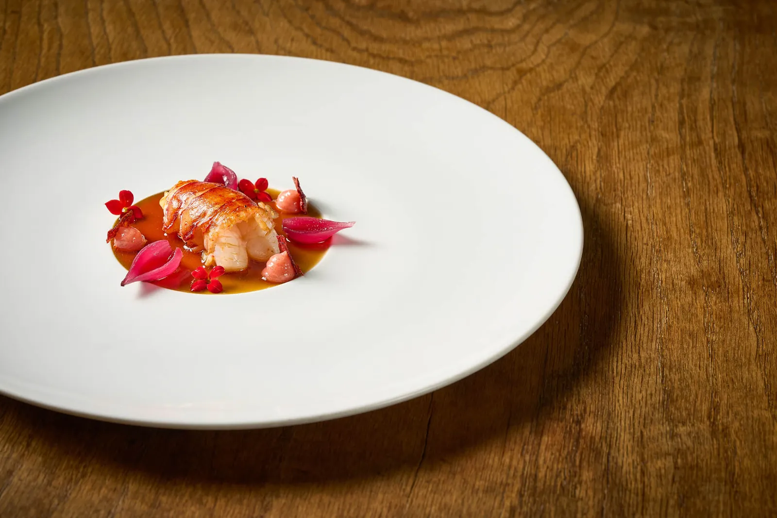 White plate with red crustacean and flowers at Azurmendi restaurant