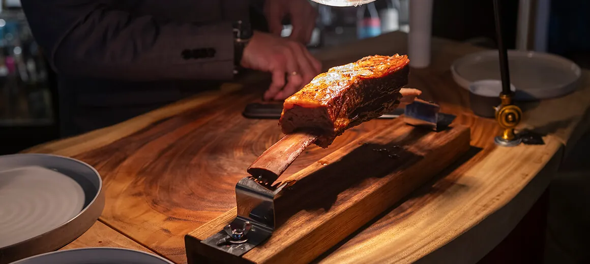 Roasted dish served on a wooden board at Back restaurant in Marbella