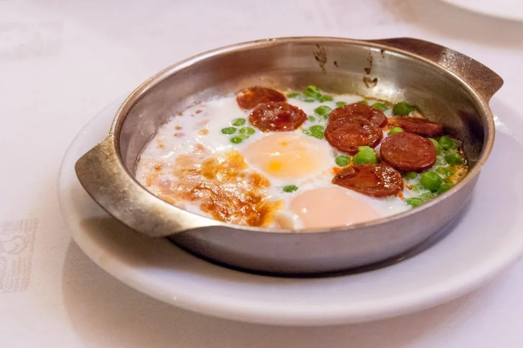 Fried eggs with chorizo and peas served at Can Culleretes restaurant in Barcelona