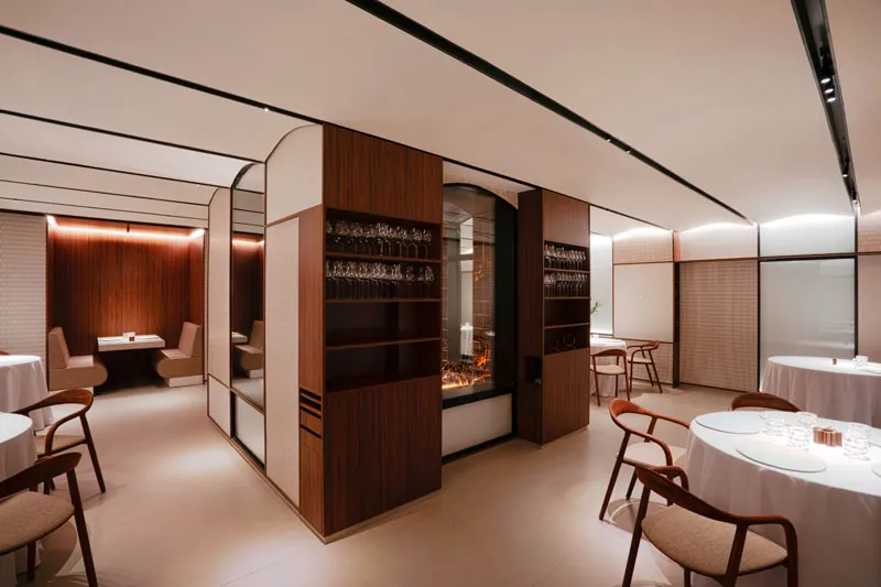Cinc Sentits restaurant room with round tables and wood panelling in Barcelona