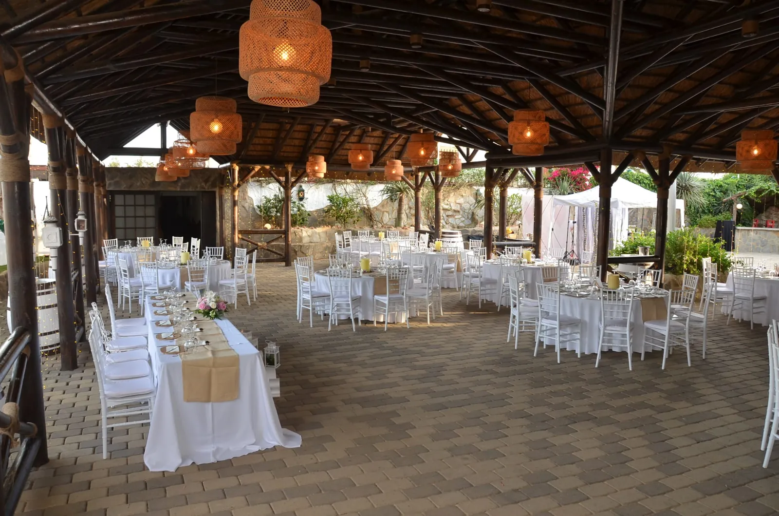 Covered reception space at Cortijo San Joaquín in Malaga with white-clothed tables