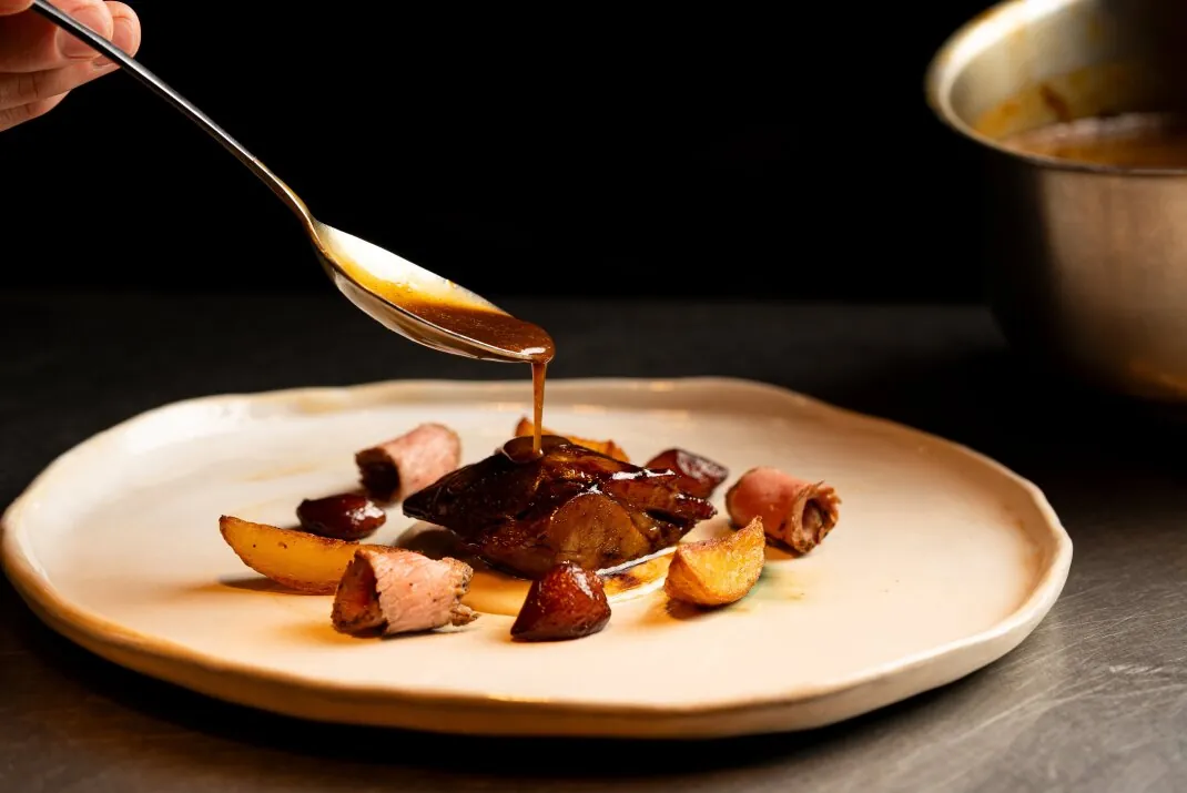 Roasted meat with potatoes and sauce served at DINS Santi Taura in Palma
