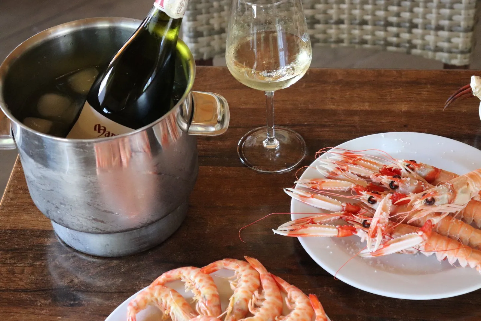 Prawns and white wine served at the table at Doña Gamba in El Rompido