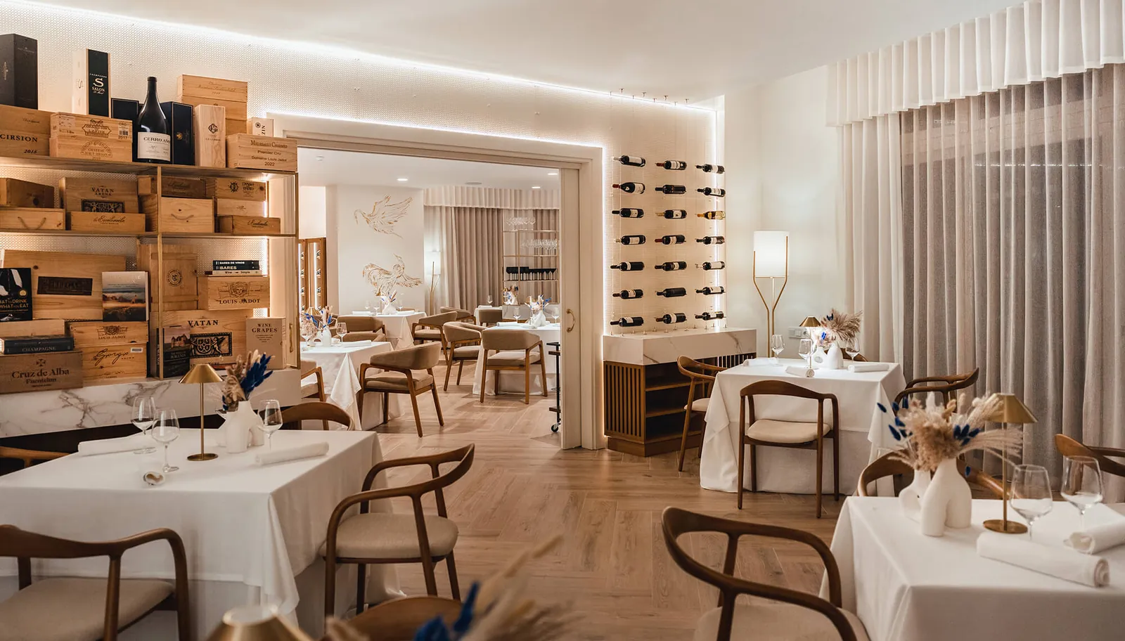Dining room of El Lago restaurant in Marbella with white tables and wine cabinet