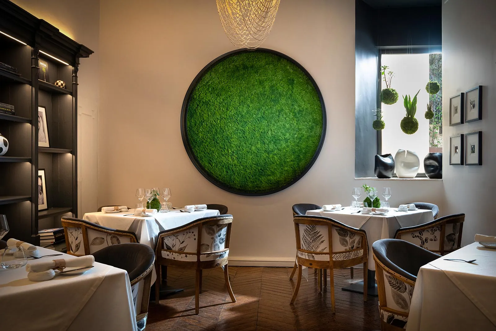 Fera restaurant dining room in Palma with round green plant panel