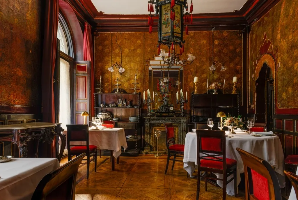 Lhardy restaurant room in Madrid with white-clothed tables and red chairs