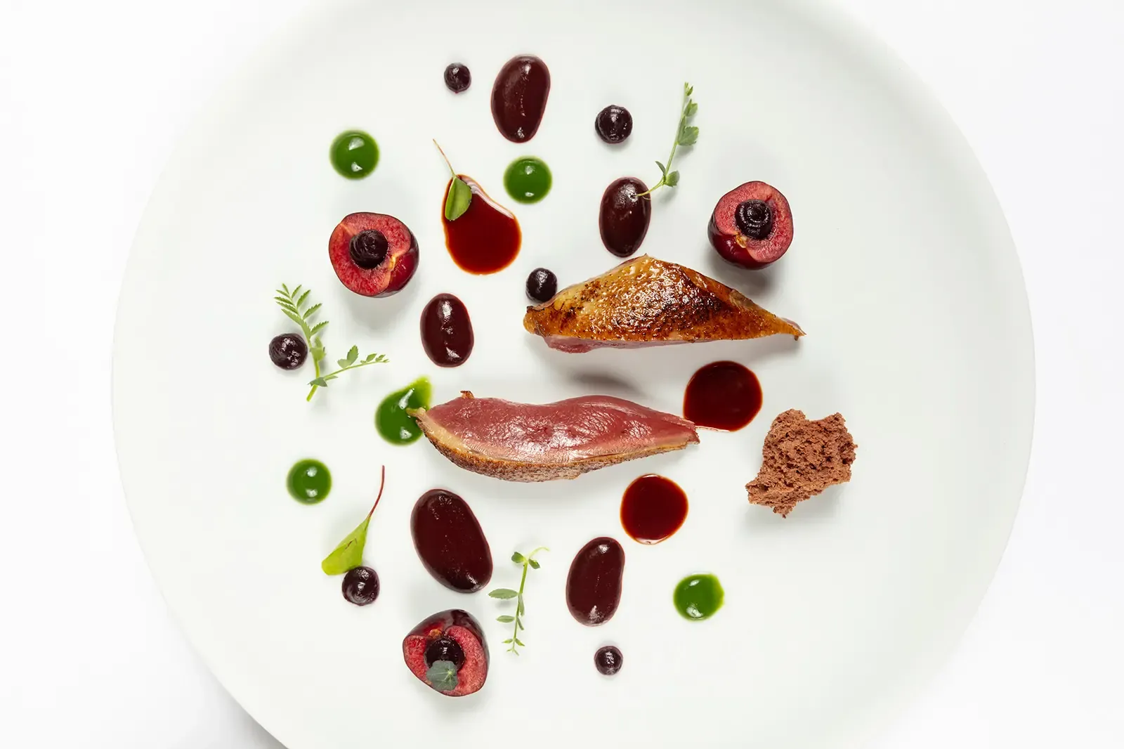 Plated dish with cherries, red meat and herbs at Marc Fosh in Palma
