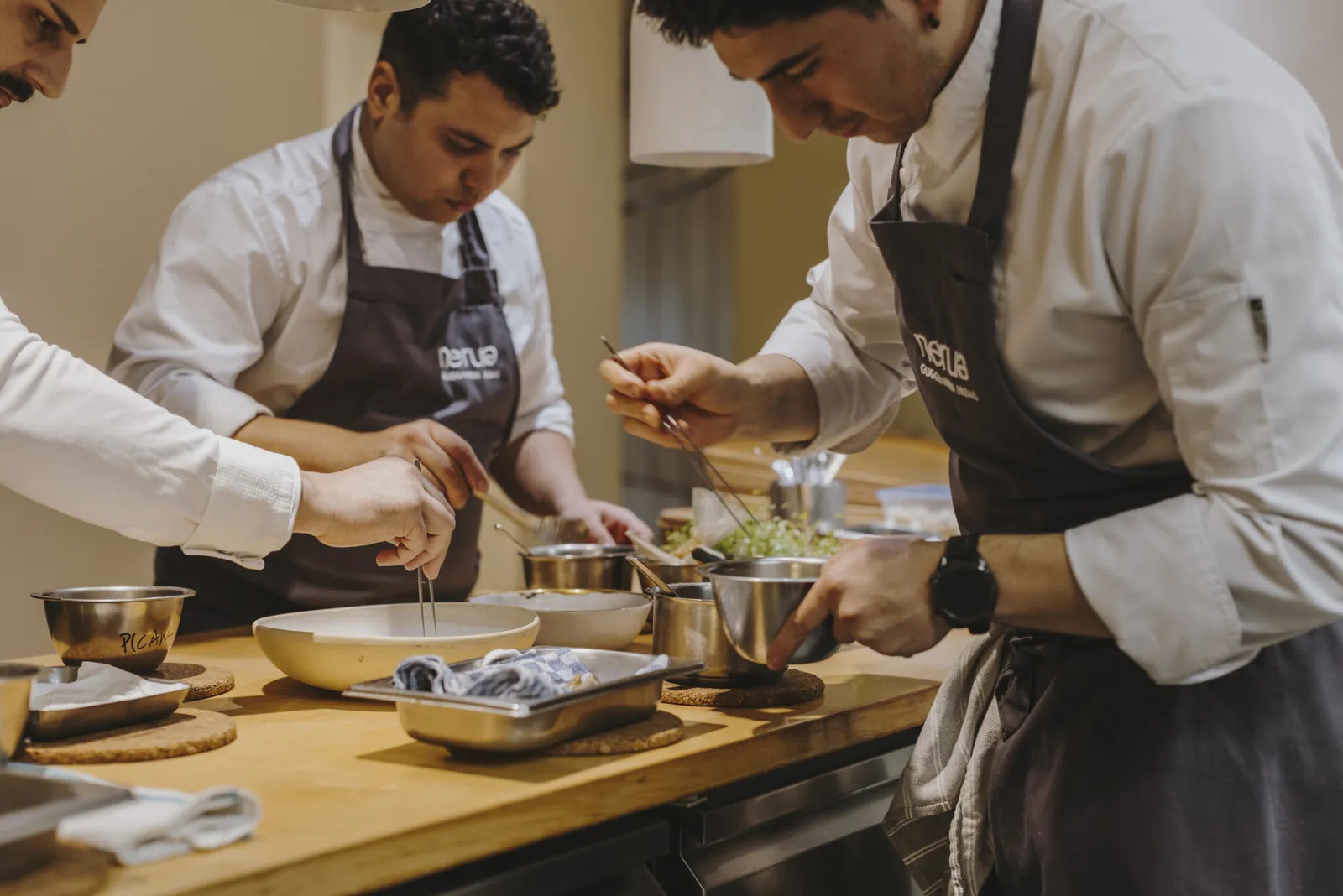 Nerua chefs at work in the kitchen, preparing dishes in bowls in Bilbao