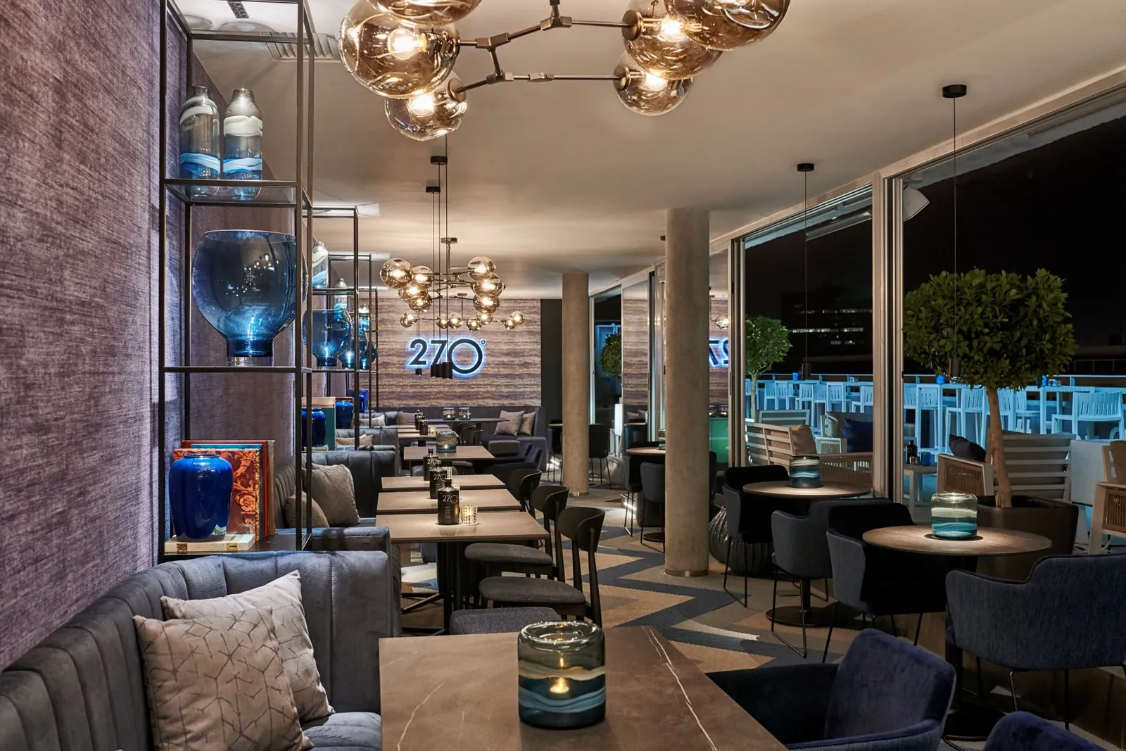 Indoor lounge of the 270 Grados rooftop with banquettes and a large chandelier in Valencia