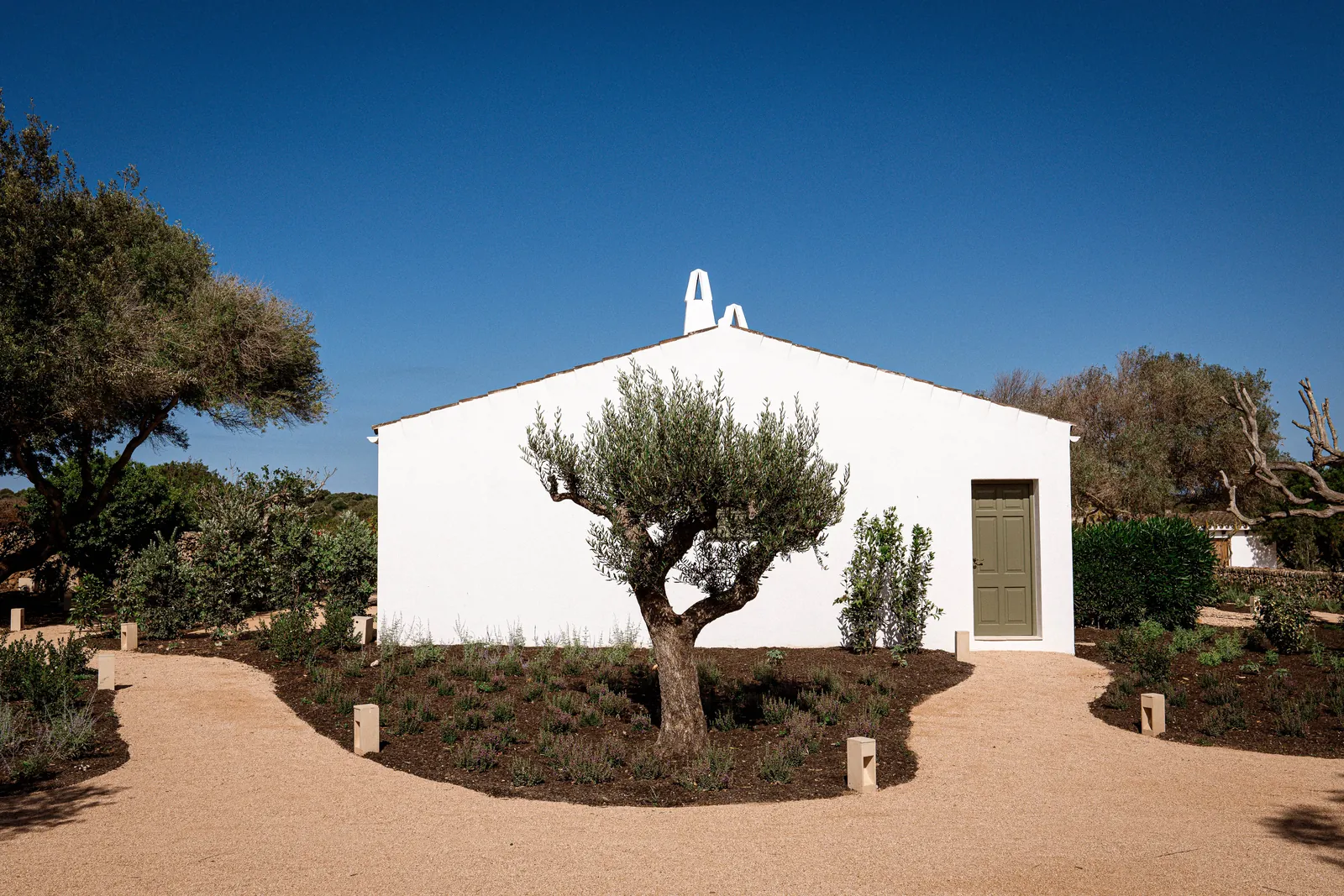 Smoix restaurant white facade surrounded by trees in Ciutadella